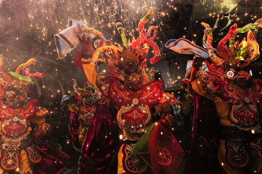 Bezoekers in oranje kleding op een druk koningsdagfestival met podium en terrassen in een Nederlands centrum