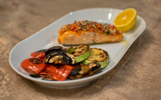 Sappige zalmfilet uit de airfryer met citroen en verse kruiden op een bord