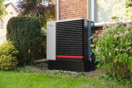 Huiseigenaar in Hardenberg bekijkt warmtepomp en subsidie-informatie bij een tussenwoning